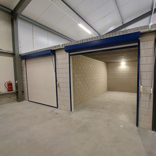 Lege opslagruimte met open roldeur in beveiligde hal – opslagruimte huren bij Eenvoudig Mobiel Opslaan