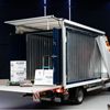 Opslagcontainer op bakwagen met open laadklep klaar voor laden Opslagcontainer open op bakwagen met laadklep – container huren bij Eenvoudig Mobiel Opslaan