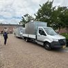 Meubel inladen via laadklep bakwagen in woonwijk – mobiele opslagcontainer 16 m³ Meubel wordt via laadklep ingeladen in bakwagen met mobiele opslagcontainer in woonwijk – Eenvoudig Mobiel Opslaan