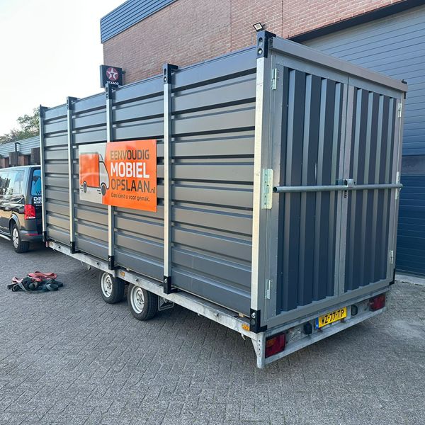 Aanhanger met oprijplaten en opslagcontainer klaar voor vertrek Aanhanger met oprijplaten volgeladen met opslagcontainer – aanhanger huren bij Eenvoudig Mobiel Opslaan