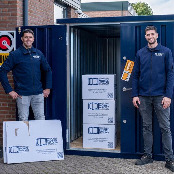 Marc en Jordy – verhuishulp team Eenvoudig Mobiel Opslaan Twee verhuismedewerkers voor open opslagcontainer met dozen – verhuishulp huren bij Eenvoudig Mobiel Opslaan